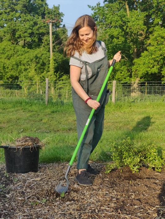 Flower farmer with hoe, wearing green overalls